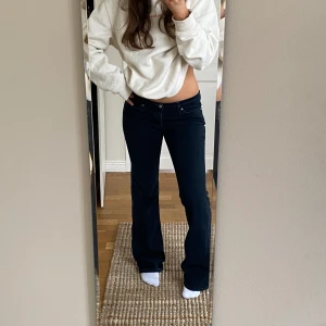 Utsvängda jeans - Svarta utsvängda jeans som är lågmidjade med supercoola fickor. Långa i benen på mig som är 168cm Innerbenslängd: 86cm Midja: 86cm