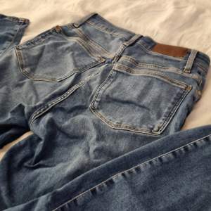 Blåa högmidjade jeans från Bik Bok, strl. M. Extrem stretch, slimfit. Knapp och dragkedja 