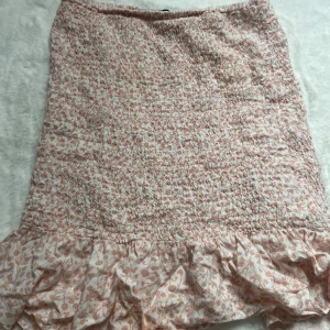 Rosablommig kjol🩷🌺 - Säljer denna kjolen med rosa blommor då den ej används💞Den sitter ganska så tajt och så har den en liten volang nertill🌺 Använd fåtal gånger så den är i ett mycket bra skick💞Lite lite genomskinlig är den👌🏼 Kontakta mig för frågor mm.🌺