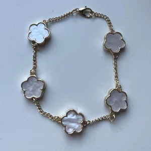 Armband vit  - Säljer detta vita armband som är med fyrklöver då det tyvärr inte kommer till andväning. Fick detta i present i mars så det är inte använt. Vet inte om det tåler vatten eller inte. Pris kan diskuteras vid snabbt affär ☺️