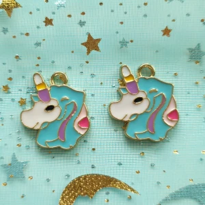 2st blå/vita enhörning berlock  - Berlocker, hängsmycke, Motiv: enhörning  Färg: vit, blå, lila, gul, guldfärgade baksida  Antal: 2st Skick: oanvända,  Går att använda till smyckestillverkning, tex sätta på halsband, armband eller göra örhängen av dem. 