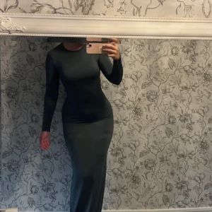 Klänning med öppen rygg - Mörkgrön klänning med öppen rygg som är köpt på bershka, använd ett fåtal gånger💕