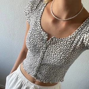 Blommig tröja - Gullig vit och svart blommig tröja från brandy Melville.