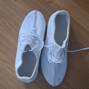 Vita sneakers - Ett par vita sneakers med snörning. Skorna har en enkel och stilren design med en mjuk ovandel och en bekväm sula.det är lite smudsig men ni kan tvätta den i tvätt maskin. Använd den max 5 gång. fungerar som ny. 