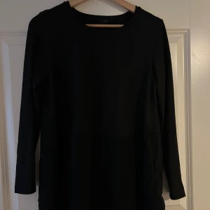 COS tröja  - Långärmad T-shirt från COS, modellen är lite längre (slutar ungefär mitt på låten på mig som är 165) och en typ peplum-modell där nedre delen av tröjan är i ett glansigt material.