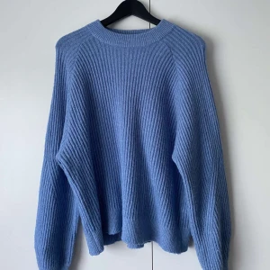 Blå stickad tröja från ellos - Jätte fin blå stickad tröja från ellos. Fick i julklapp men för stor för mig. Orginal pris 899kr Använd 1 gång
