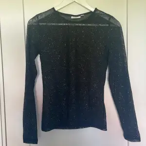 Glittrig svart långärmad tröja i nysick, aldrig använd. Perfekt tröja för fest eller när du ska göra dig fin❣️ OBS: Glittret kan falla av Genomskinlig tröja 