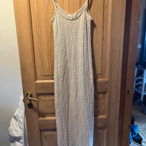Lång sommarklänning  - Beige sommarklänning från Hm. Går ner till mitten av ankeln på mig (178 cm)  Testad men aldrig använd ute