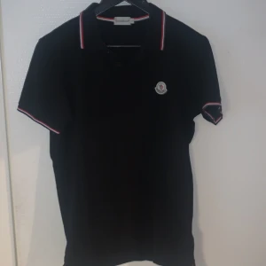moncler pike  - Säljer en riktig snygg moncler piké i svart färg och är i storlek L men passar även M, Scan finns och för flera frågor är det bara att skriva!