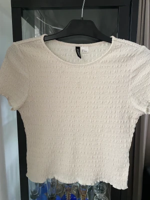 T-shirt  - Kort t-shirt från H&M, strl s. Bruten vit färg  Använd, men i bra skick