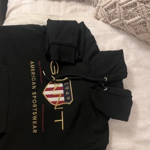 Hoodie - Svart Gant hoodie i storlek M, men passar också lika bra som S!  Nypris  1200kr. Inte använd många ggr och har inga defekter förutom ett litet hål längst ner på höger sida