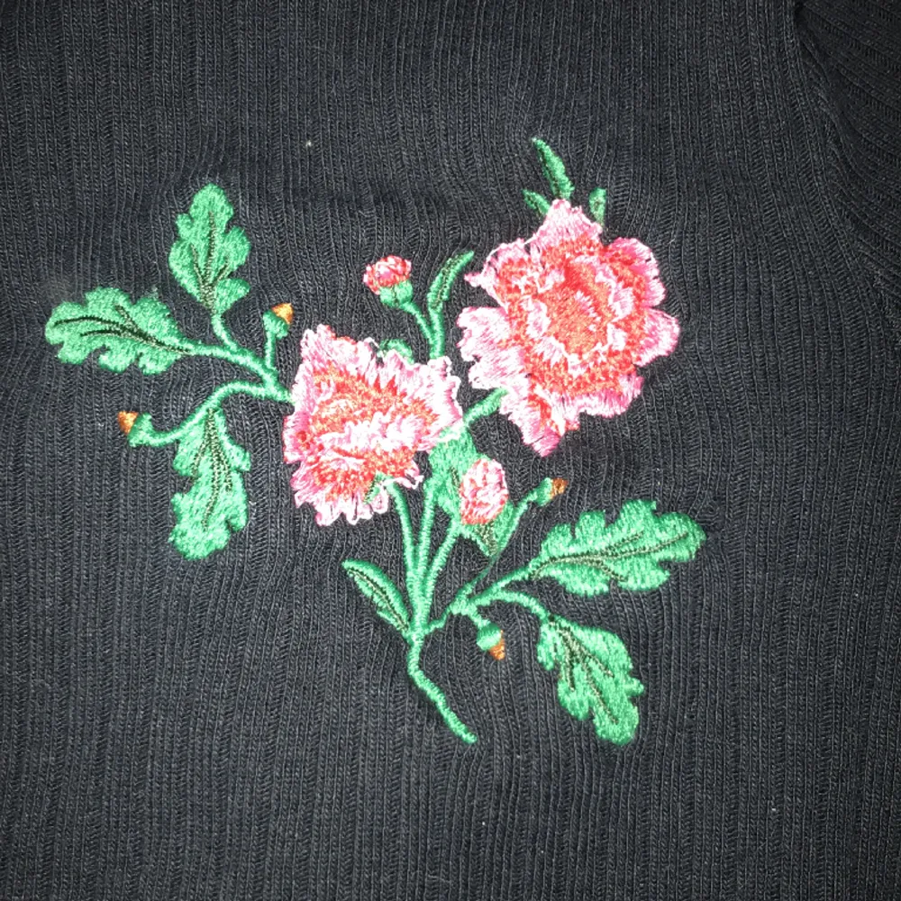 En svart, ribbad och långärmad tröja med en ros på. Säljer för att den börjar bli liten. Den ser ny ut och är ifrån Cubus.. Tröjor & Koftor.
