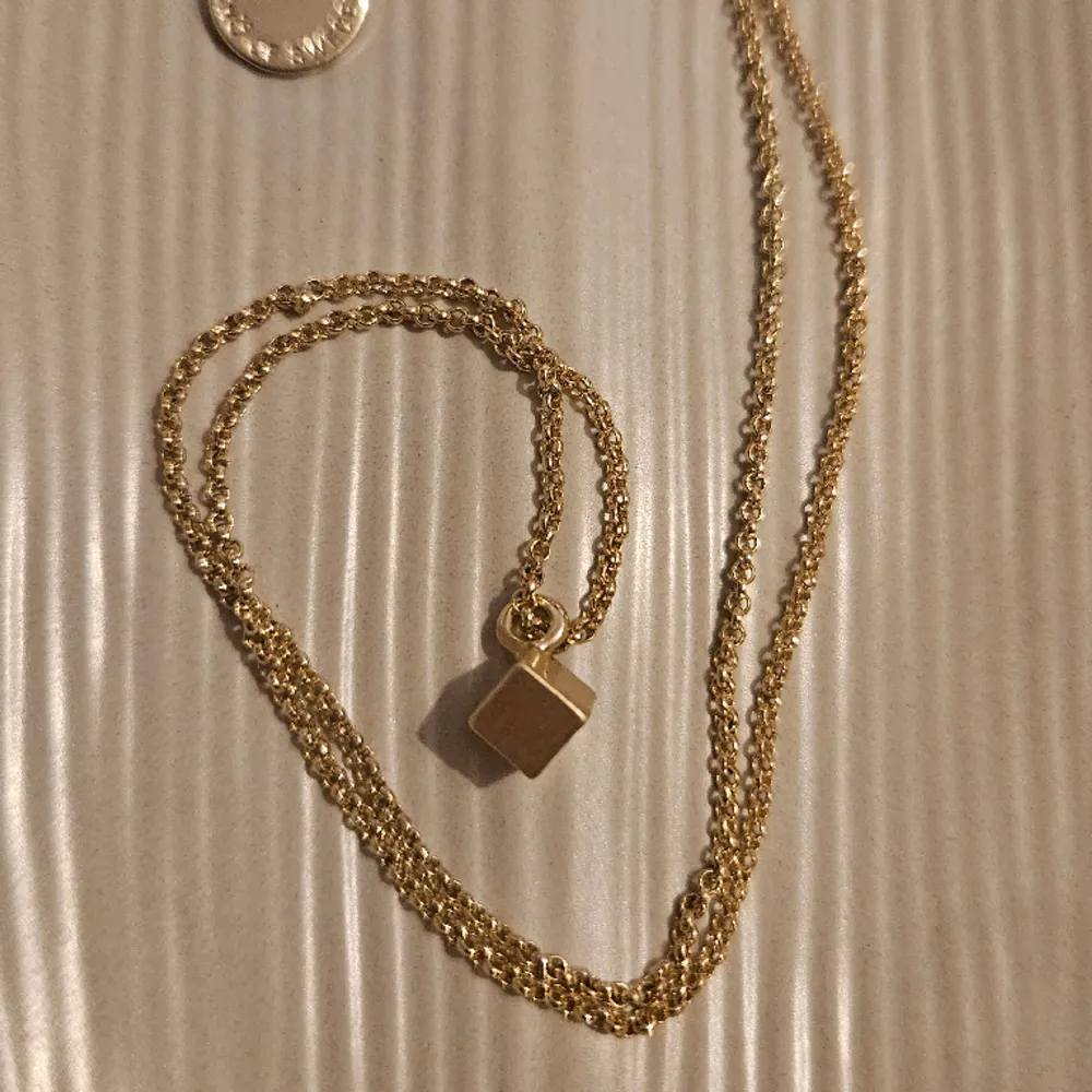 Ett fint, äkta guldhalsband från  SNÖ Of Sweden. Halsbandet har en tunn guldkedja med ett hänge i form av en liten kub.   Kedjan är ca 55 cm lång kuben ca 4 mm3   Bara använt det en gång så väldigt bra skick!. Accessoarer.