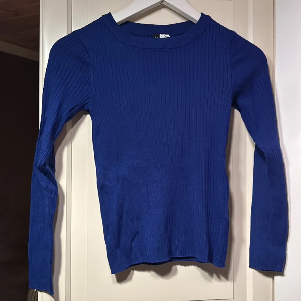 En blå tröja från divided hm i storlek xs . Stickat.