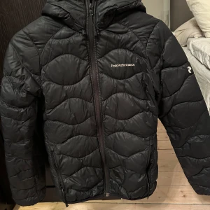 Peak performance jacka  - Peak performance jacka i rätt så använt skick. Har en reva på mitten av magen ungefär där det sitter tejp för att hålla dunet inne i jackan. Nypris 2400kr