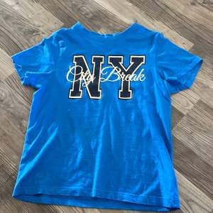 En blå T-shirt som det står NY city break på. Den är använd några fåtal gånger och är i väldigt bra skick. Storlek 146/157  