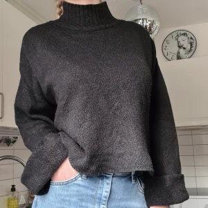 Svart stickad tröja  - Svart stickad tröja, polo, vid modell med långa ärmar. Nopprig men fortfarande användbar, syns på sista bilden. Kom med prisförslag 😊  Material 78% Akryl, 20% Polyester, 2% Elastan.