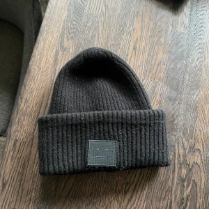 Svart acne mössa - En svart acne mössa som är köpt för några årsedan men fortfarande bra skick. Nypris 1600kr
