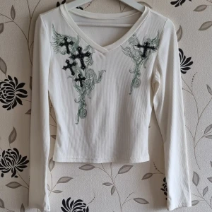 Y2K långärmad vit tröja, Strl: M, Kors/Cross, Harajuku,  - Vit långärmad tröja i "Y2K"-stil, den är ribbad med kors som tryck, något croppad modell. Fint skick! OBS! Jag kan inte skicka något vecka 26.