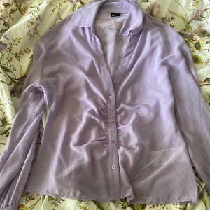 Lila blus - Genomskinlig lila blus i storlek L, men passar även fint på mindre storlekar
