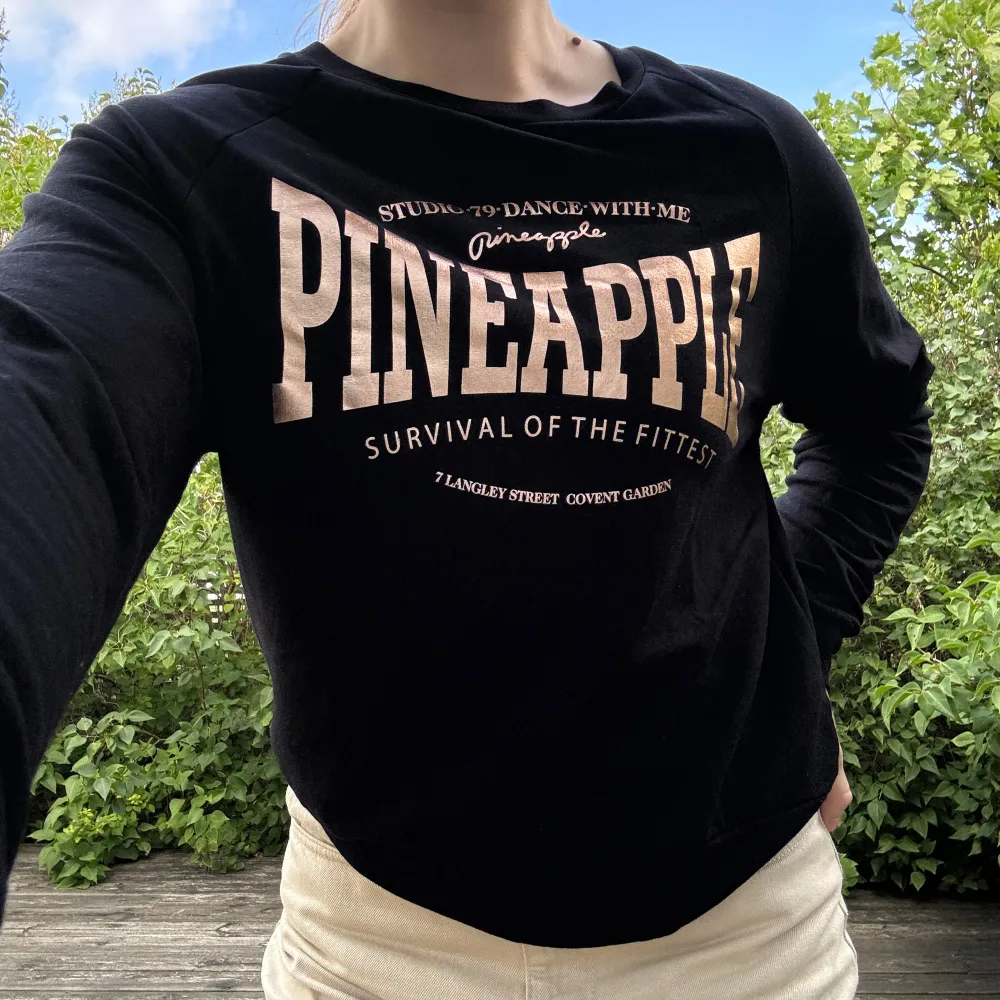 Nyskick! Stretchig, sval och skön, svincool: svart crewneck från dansskolan ”Pineapple” i London med logga i skinande roséguld. Storlek: S. Material: 95% viskos + 5% elastan. Tröjor & Koftor.