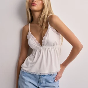 Nelly topp - ”Lace bow topp” från Nelly. Knappt använd, säljer då den inte kommer till användning 