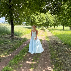 Ljusblå balklänning med fina detaljer👗🌸 - Jättefin blå balklänning med fina paljetter och korsett så man kan justera passform själv! Jag är 158 och jag tycker att den satt väldigt bra men funkar även om man är lite längre. Skriv för fler bilder🫶🏼Använd av mig en gång men har en tidigare ägare