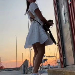 Sommarklänning - Jätt gullig vit sommarklänning från Nelly med öppen rygg med knyt och volangkjol. Använd endast några gånger o perfekt till studenten eller skolavslutning. Storlek S/XS