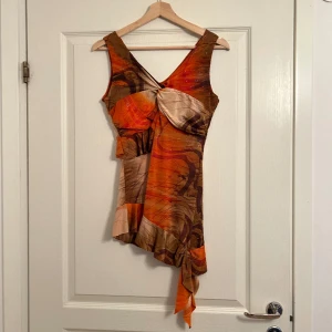 Mönstrad topp - Otroligt fin mönstrad topp med volanger och glitter. 