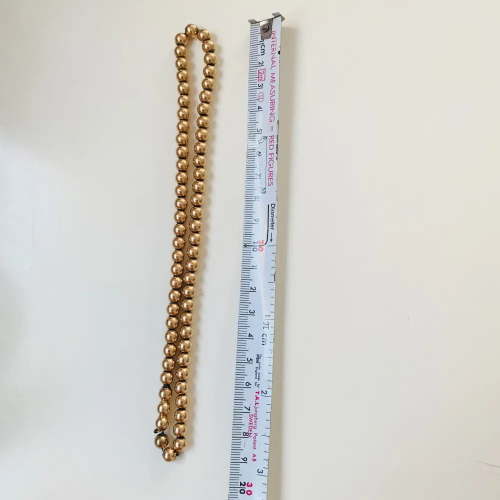 Vackert halsband med guldfärgade pärlor  Okänt material . Accessoarer.