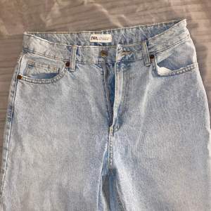 Zara Straight Fit medel/hög midja Jeans i färgen Ljusblå. Rivna jeans vid knäskål. Normal fit med kedja. Storlek 40, passar till folk med storlek M i byxor. Jag är 163cm lång. Använd några gånger. 