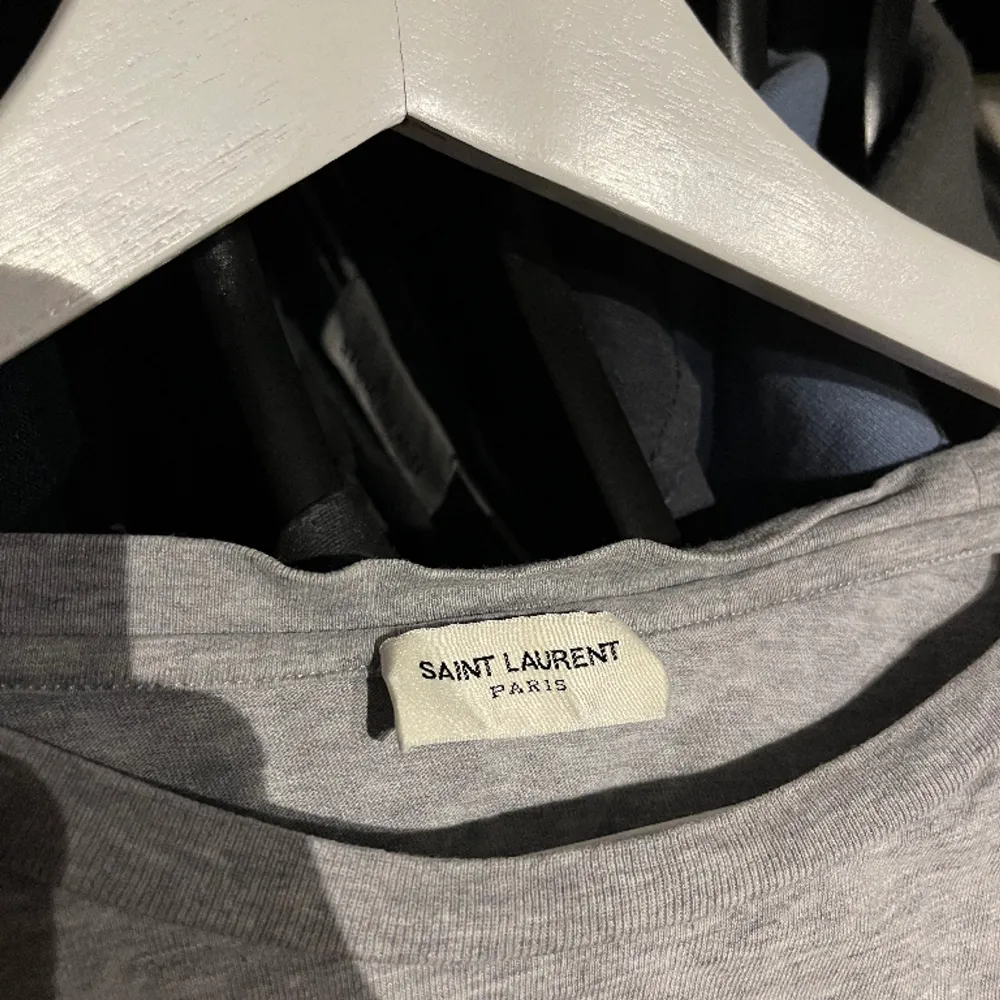 Säljer min Saint Laurent T-shirt. Den är i bra skick skulle säga 8,5/10. Storlek L men liten i storleken skulle säga S. . T-shirts.