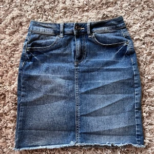 Jeanskjol, Pieces - Blå jeanskjol med snygga detaljer från märket pieces ( köpt på vero Moda). Midjemåttet är 32 cm och längden på plagget 41 cm. Det är en åtsittande modell men har ett väldigt stretchigt material. Som ny! Storlek Xs💙