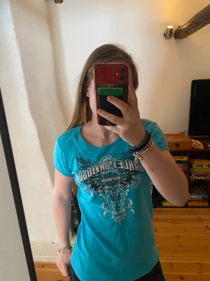 T-shirt - En turkos t-shirt med tryck fram och bak storlek M den som köper står för frakten (46kr)