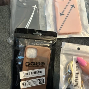 Samling av mobilskal och örhänge 50kr - En samling av 3 olika mobilskal för iPhone 14 och ett par guldiga örhängen (botega dupes). Allt säljes som ett paket för 50kr.   Jag kan mötas upp i Stockholm eller skicka paketet men då står du för frakten.