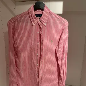 Säljer denna snygga Ralph lauren skjorta, randig i rosa vit då den inte längre kommer till användning. Strl S 10/10 skick. Ur snygg till sommaren.  Vid funderingar tveka inte att höra av sig🦈