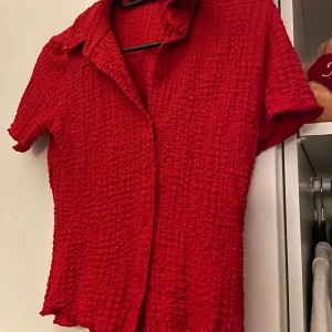 Röd blus  - Enkel och fin röd blus. Orättvis bild då färgen röd är skrik röd i verkligheten och lyser. Tveka inte höra av er vid ytterligare funderingar ☺️