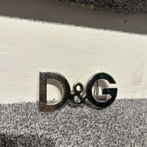 Bältesspänne 2000-tal stil  - Bältesspänne med D&G logga. Säljes i befintligt skick!  Repor finns men inget man tänker på när man använder det i ett bälte.  Inköpt utomlands 
