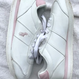 Ralph Lauren skor - Säljer ett par vita Polo Ralph Lauren skor med rosa detaljer för att de är för små. Använda 2-3 gånger och är i bra skick! 💕💕