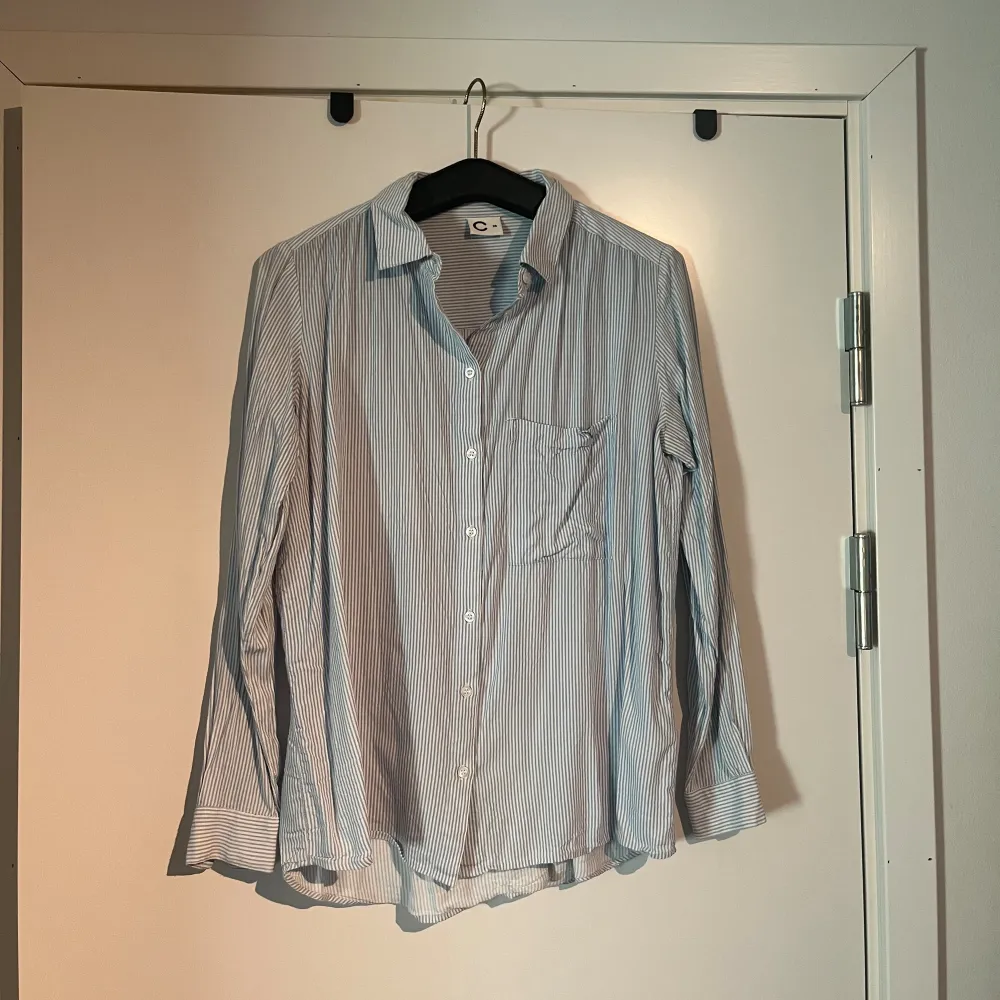 Blå skjorta med vita ränder. Avslappnad modell. Pris kan diskuteras😊. Skjortor.