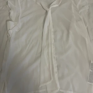 Vit blus - En jätte fin vit blus som passar perfekt t sommarn. Man kan också knyta den uppepå. Den är från Only i strl 40. Men den skulle även passa 36. Använd ett fåtal ggr.