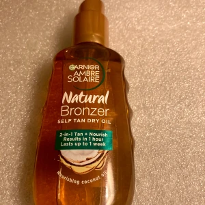*NY*Self Tan Dry Oil, 150 ml, Fr Garnier - Brun utan sol Garnier - Ambre Solaire Natural Bronzer 2-in-1 bi-phase Self Tan Dry Oil är en brun-utan-sol-olja som ger en vacker och solbrun lyster. Berikad med näringsgivande kokosolja och ger en fin solbrun färg som ser naturlig ut.  Ca 167 kr ny