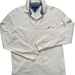 Långärmad Tommy Hilfiger Piké - Säljer en Tommy Hilfigger piké! Andvänd 1 gång, skick 10/10. Storlek S men passar M. Nypris ca 700kr, mitt pris 199kr. Färgen är lite creme white. Skicka vid nån fundering! Pris kan diskuteras. 