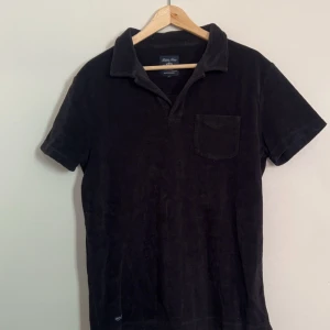 Robbie moor frotté piké - Snygg piké från Robbie moor, perfekt till sommaren! Den är i fint skick! Färg:Svart Storlek:Medium