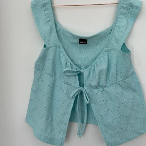 Topp - En sommrig topp från Gina med rosett knyta som går att ta upp och spänna in och ut