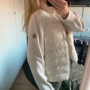 Moncler cardigan - Så fin vit moncler cardigan!! Storlek L men passar mindre storlek, har oftast S och såhär sitter den på mig. Så skulle säga XS-M. Självklart är den äkta, dock inget kvitto, qr koden på bilden bevisar äktheten. Nyligen kemtvättad, skriv för fler bilde