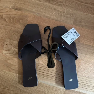 Sommartofflor och sommar klackar  - Säljer ett par helt nya tofflor i storlek 41. Pris 100kr. Säljer även ett par nya sommarklackar för 100kr. Använt de 1 gång. 