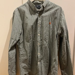 Ralp lauren skjorta grön vit rutig  - Skjorta large slimfit grön vit rutig med orange häst. Två knappt har blivit utbytta där av lägre pris 