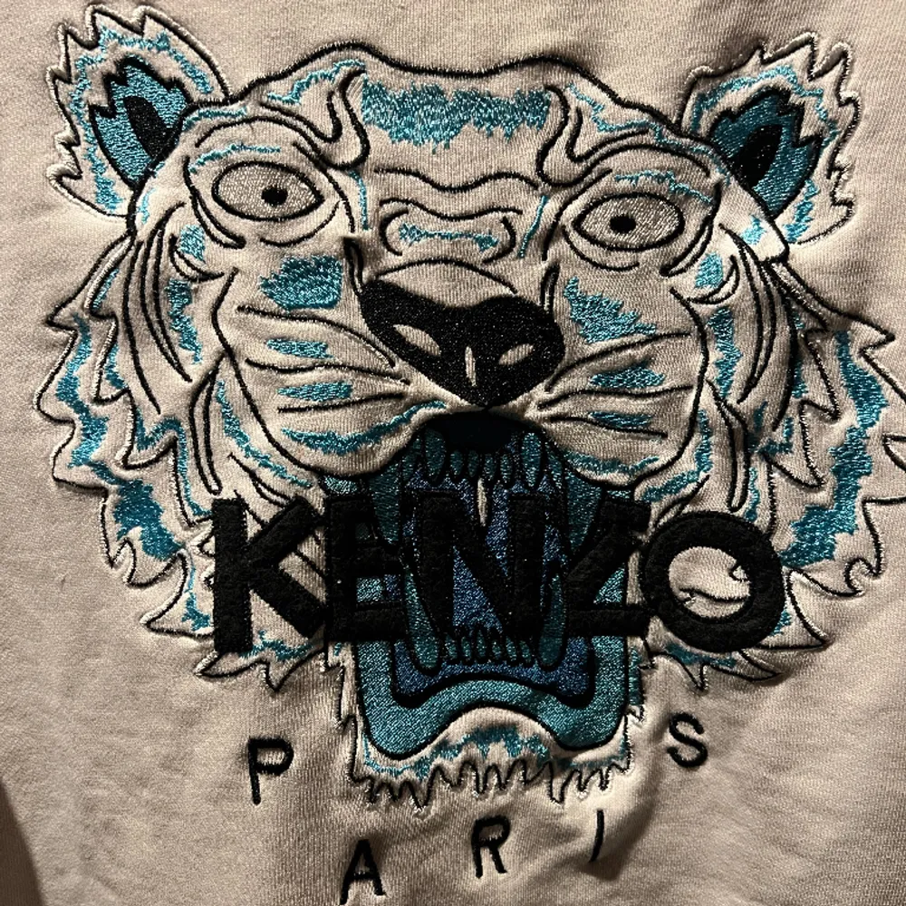 Kenzo sweatshirt i vit med en blå tiger, tröjan har inga defekter och original priset är 2299 kr. Hoodies.