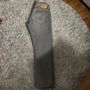 Jack And Jones Jeans grå - Säljer ett par gråa Jack and Jones jeans för att jag inte använder dom längre. Skick: 9/10 Färg: Grå Storlek: W32/L34 Om du har frågor och vill ha bättre bilder är det bara att skriva till mig!